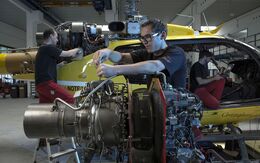 2 Techniker servicieren in einer Wartungs-Halle der HeliAir Triebwerk und Hauptrotor eines Christophorus-Hubschraubers.