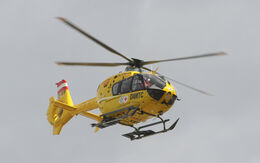 Fliegender Christophorus 33-Notarzthubschrauber bei grauem Himmel.