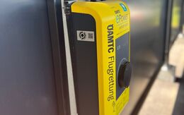 Auf dem Bild sieht man eine sogenannte Wallbox an der E-Fahrzeuge zum Laden angesteckz werden können. Die Wallbox ist gelb und trägt den Schriftzug der ÖAMTC Flugrettung.