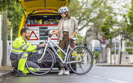 ÖAMTC-Pannenfahrer kontrolliert die Beleuchtung eines Fahrrades von einer jungen Radfahrerin.
