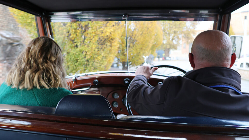 Redakteurin Verena Schauer und Fahrer auf den Vordersitzen des Rolls Royce Phantom III, vom Rücksitz fotografiert. Sie sehen beide nach vorne, man sieht nur den Hinterkopf.