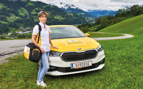 Hauskrankenpflegerin Heidi posiert vor ihrem Auto in den Bergen.