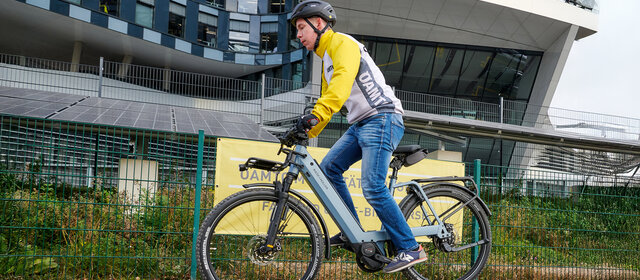 Ein Mann in gelber Jacke bei einer Vollbremsung am Fahrrad