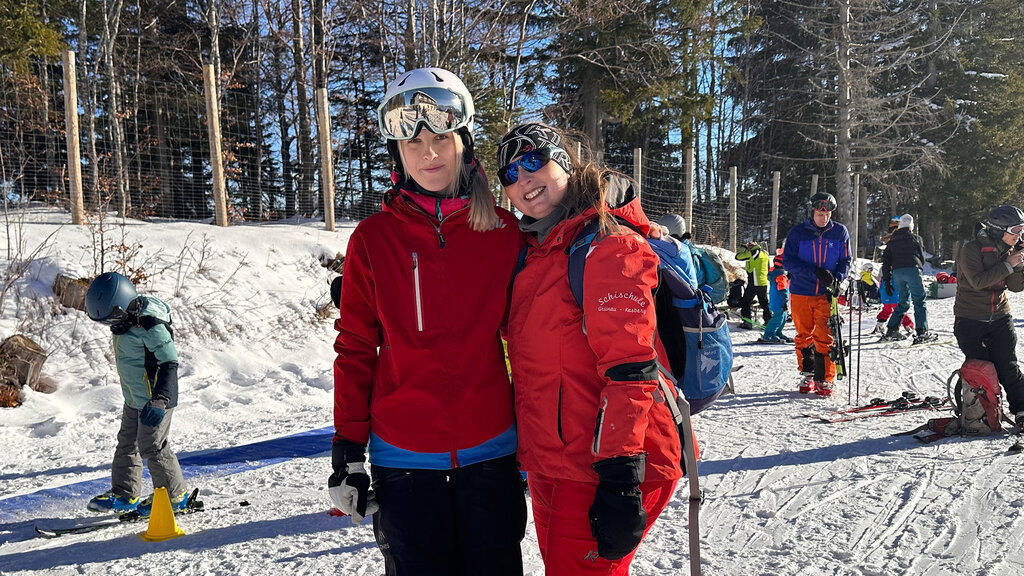 Zwei Skilehrerin der Skischule Kasberg in rotem Skigewand.