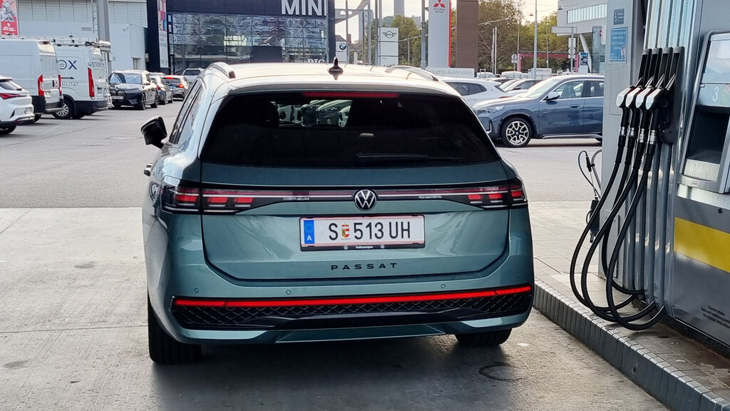 Ein lindgrünes Auto steht an der Tankstelle